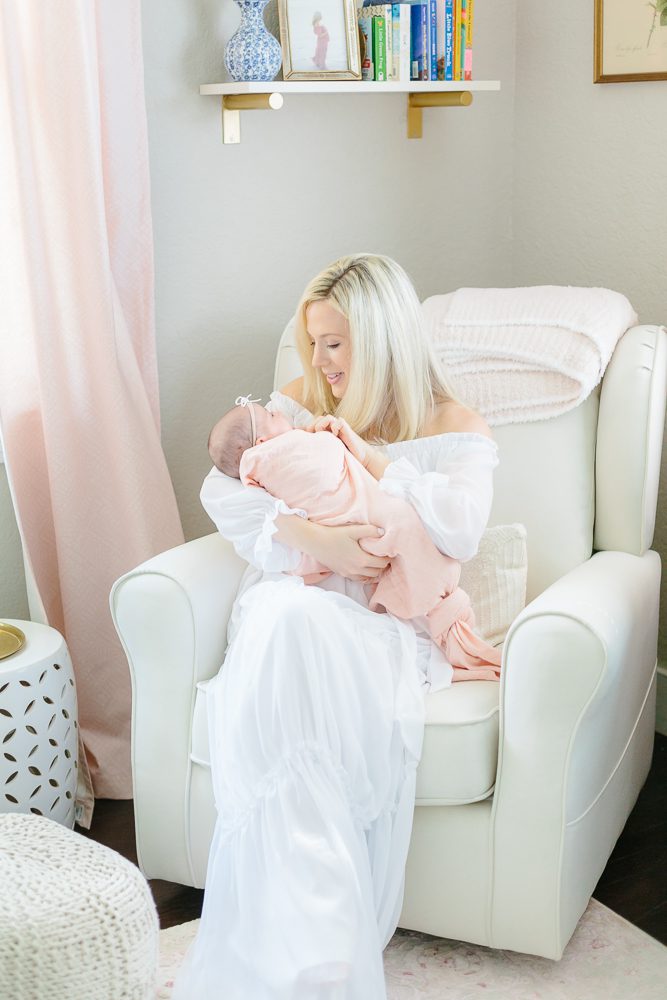 Mom and dad with newborn baby girl in light pink swaddle